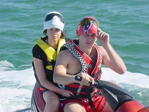 Couple on jet bike wearing sports utility masks